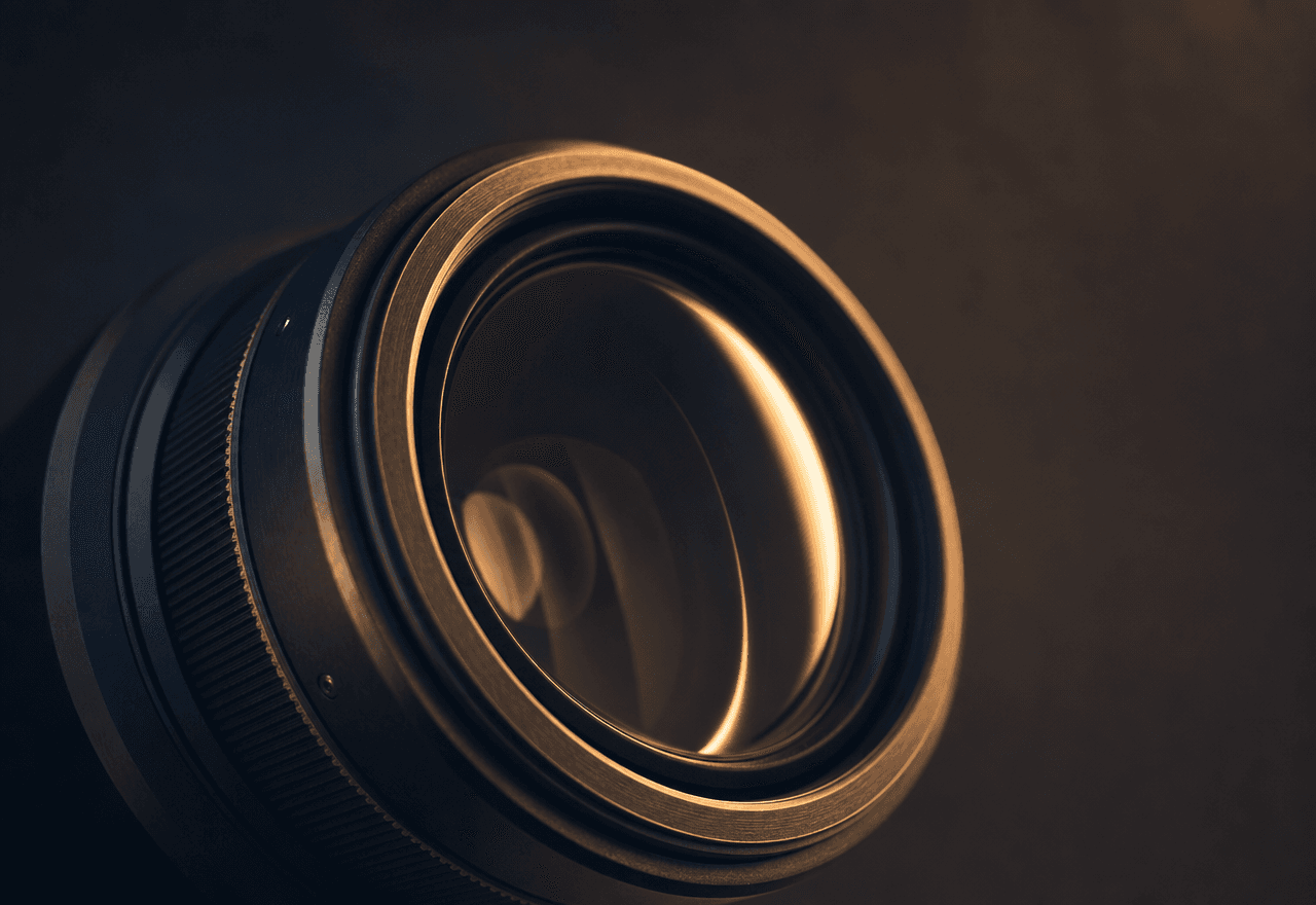 An extreme close-up of a camera lens lit by warm tungsten light.
